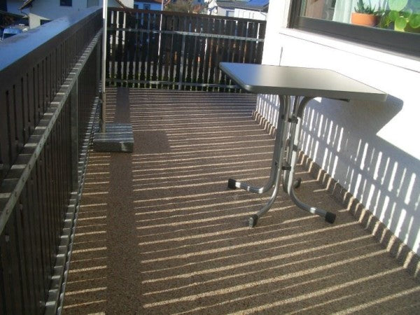 Eckbalkon mit beigen Steinteppichboden.