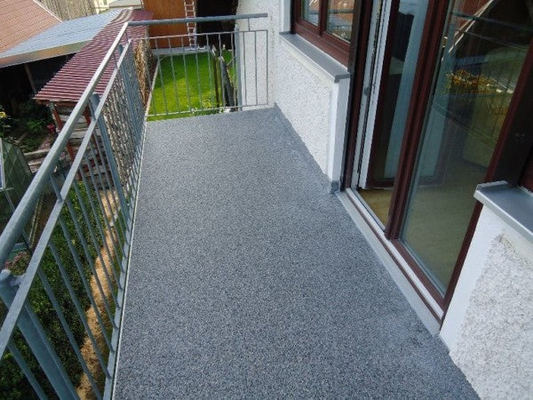 Balkon mit grauem Steinteppich-Boden.
