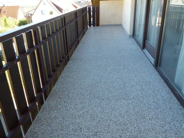 Balkon mit grauem Klick Steinteppich als Bodenbelag.