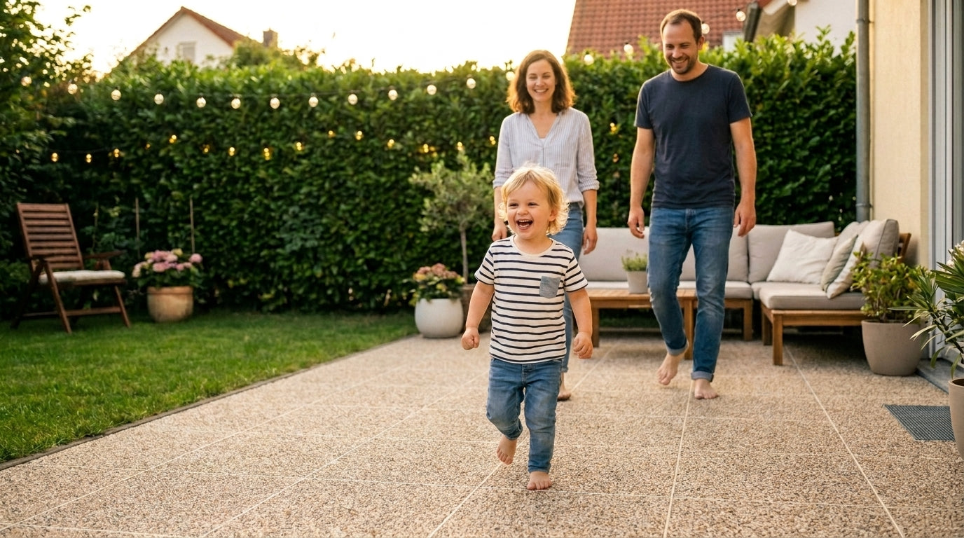 Familie barfuß auf RENOfloor Steinteppich-Terrasse (50×50 Elemente, Farbe Sand) — sorgenfrei und sicher