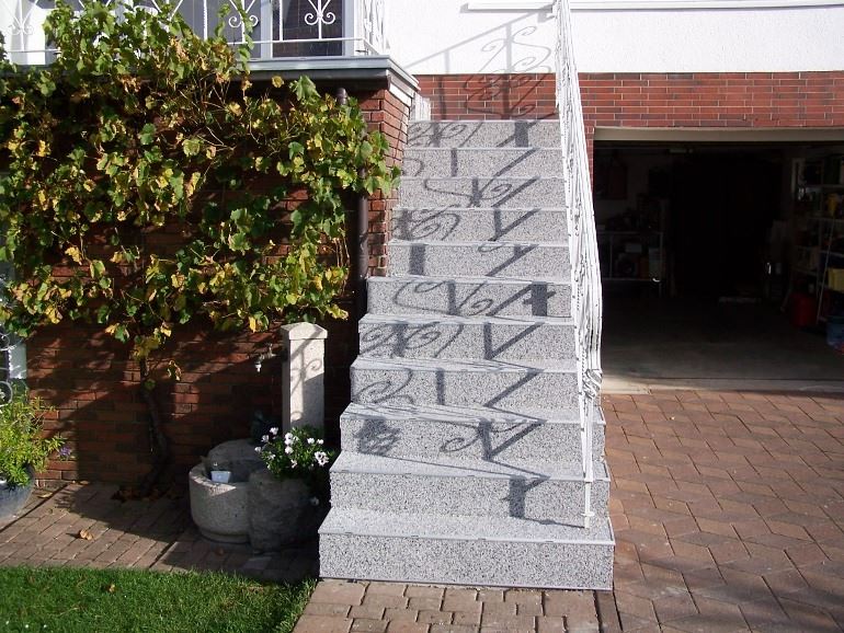 Treppe die zur Terrasse führt mit Steinteppich-Stufen.